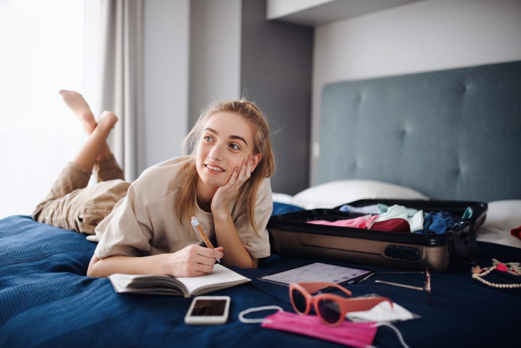Portrait,Of,Young,Woman,Writing,Notes,And,Packing,Clothes,Into