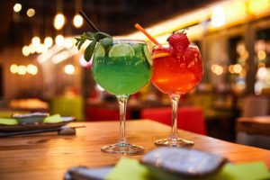 Two fruit cocktail drinks on a table in a bar for student discount offers